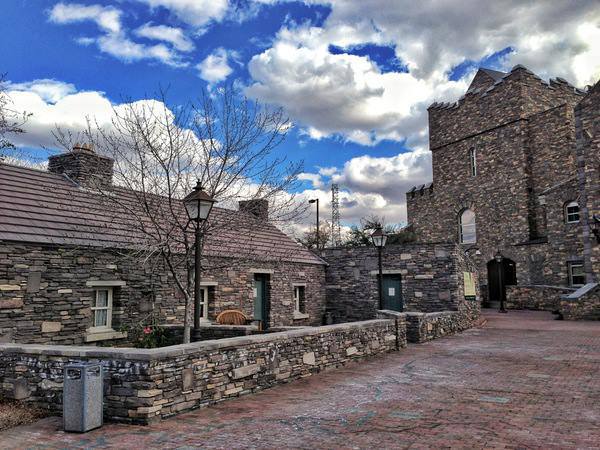 Brown stone buildings and a brick paved walkway.