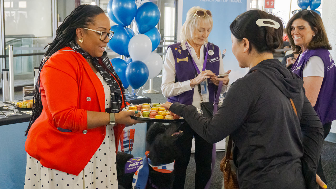 ssistant Director Roxann Favors hands out macaroons to Air France passengers.
